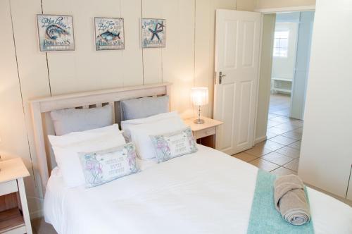 莫塞尔湾Barefoot Lodge, Mossel Bay的卧室配有白色的床和枕头。