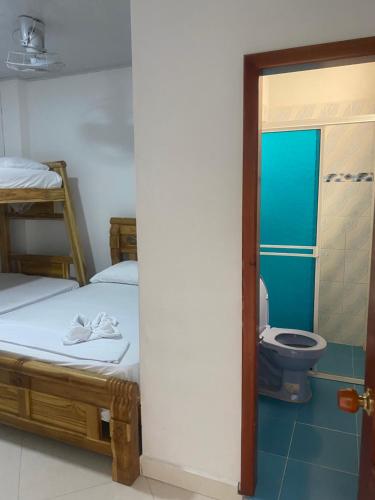内科克利Sweet Dreams Necocli的客房设有两张床和一间带卫生间的浴室。