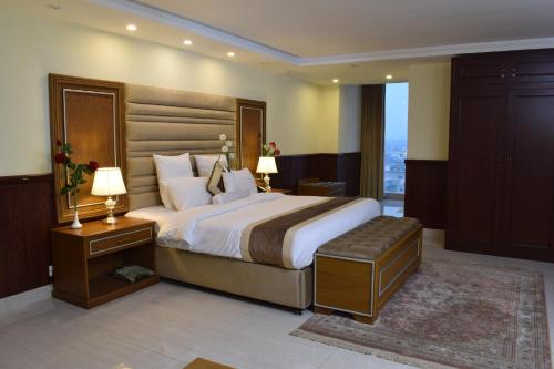 拉合尔Al Nafoura Hotel的一间卧室设有一张大床和一个大窗户