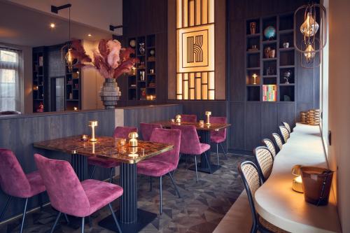 维格尔The Yard hotel Noordkade的一间餐厅,房间内设有粉红色的椅子和桌子