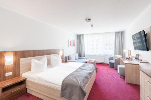 诺伊鲁平诺伊鲁平运动酒店的酒店客房带大型白色床和椅子
