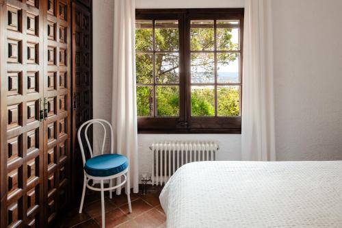 普拉加德阿罗Villa Ventisca的一间卧室设有一张床、一个窗口和一把椅子