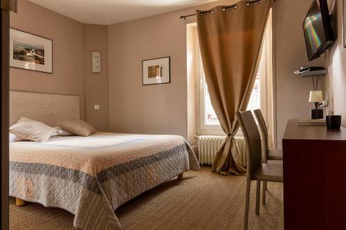 波特莱斯内埃德加酒店的一间卧室配有一张床、一张书桌和一个窗户。
