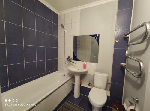 阿拉木图Уютная однокомнатная квартирка, в тихом спальном районе, недалеко от Аэропорта的浴室配有盥洗盆、卫生间和浴缸。