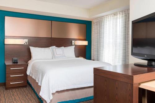 大急流城Residence Inn by Marriott Grand Rapids West的配有一张床和一台平面电视的酒店客房