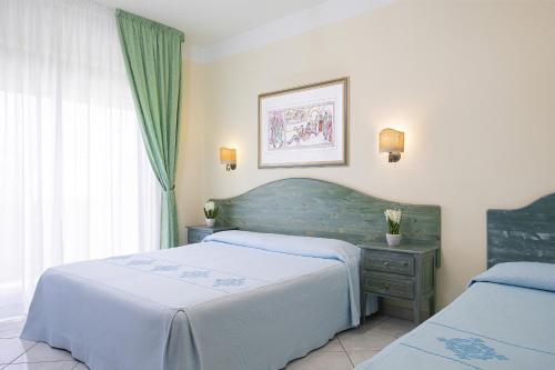 奥罗塞伊玛丽娅罗萨日亚酒店的一间卧室设有两张床、一张桌子和一个窗口