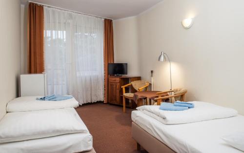 拉塔OSW Kaper的酒店客房设有两张床、一张桌子和一张书桌。