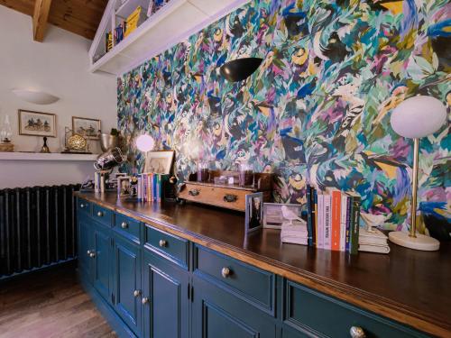 纳文Balsoon Lodge的厨房配有蓝色橱柜和色彩缤纷的墙壁
