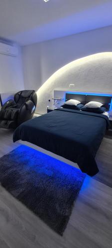 斯拉沃尼亚布罗德Studio-Apartment VAL - Luxury massage chair - Private SPA- Jacuzzi, Infrared Sauna, , Parking with video surveillance, Entry with PIN 0 - 24h, FREE CANCELLATION UNTIL 2 PM ON THE LAST DAY OF CHECK IN的一间卧室配有两张蓝色灯床。