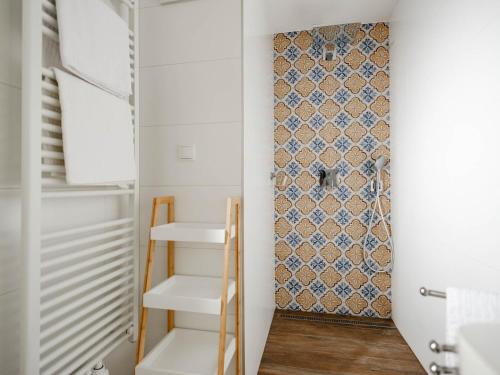 HerrnbaumgartenFerienhaus Sporr的一个带白色架子和图案墙的小衣柜