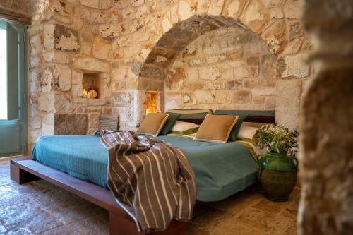 奥斯图尼Ostuni Art Resort的卧室配有一张石墙床