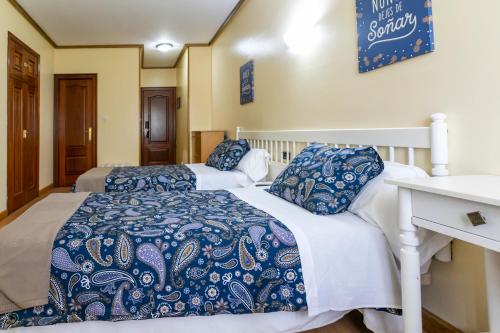 费罗尔Hotel América Ferrol的两张带蓝色和白色床单的床