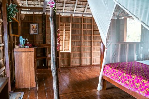 Yennanas BesirMethos Homestay - Raja Ampat的铺有木地板的客房内设有一间卧室和一张床。
