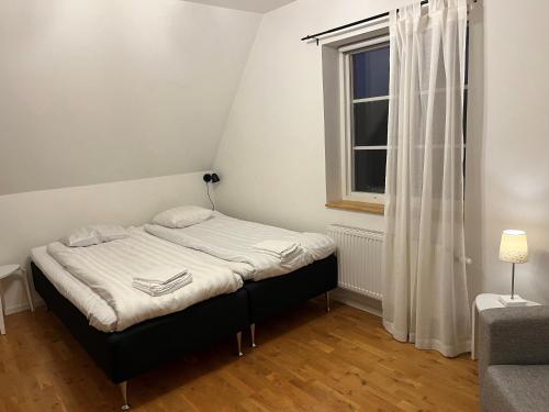 维斯比Österport - Visby Lägenhetshotell的一间小卧室,配有床和窗户