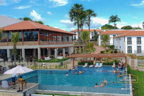 皮雷诺波利斯Resort Quinta Santa Bárbara OFICIAL的一群人在酒店的游泳池里
