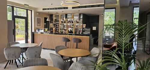阳光海滩Emilia Romana Park的一间带2张桌子和椅子的餐厅和一间酒吧