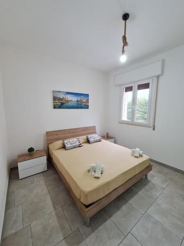 CampomarinoAppartamenti Mirante的一间卧室设有一张大床和一个窗户。