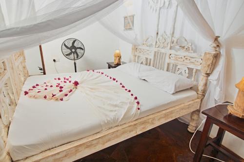 瓦塔穆Mvuvi Lodge的卧室配有白色的华盖床