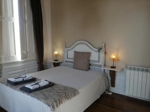 洛萨Vila Delfina的卧室配有白色的床和2条毛巾