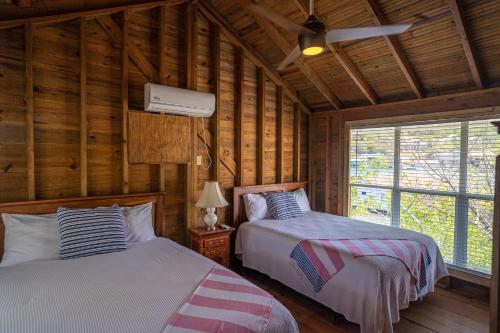 Oak RidgeOcean Breeze Villa Rentals的木墙客房的两张床