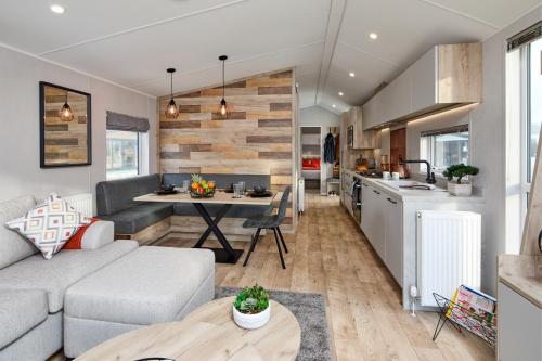 巴森斯韦特Elite Holiday Caravan的客厅以及带沙发和桌子的厨房。
