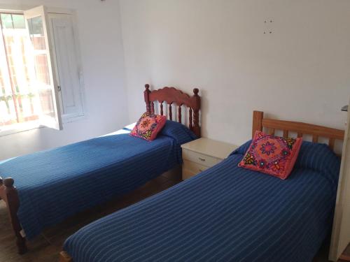 GualeguaychúComo en casa的卧室内的两张床,配有蓝色床单和粉红色枕头