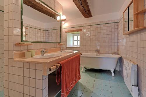AlexainLe Moulin neuf的浴室设有2个水槽、浴缸和镜子