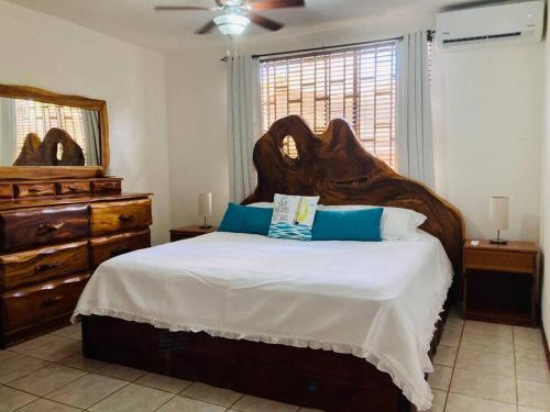 雅科La Mona Beach House的一间卧室配有一张带蓝色枕头的大型木制床。