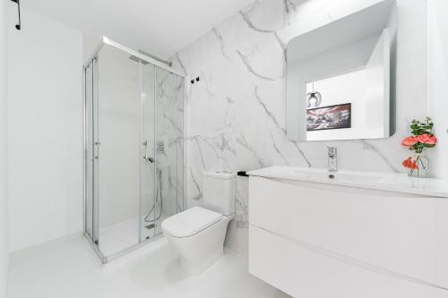 圣米格尔德萨利纳斯Apartamento Los Alcores的带淋浴、卫生间和盥洗盆的白色浴室