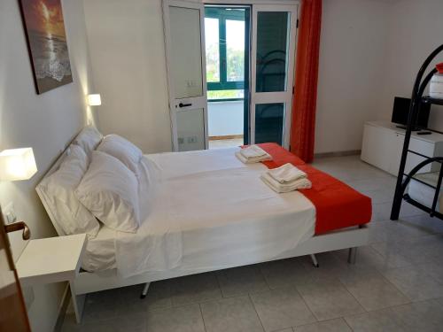 托雷圣乔万尼乌Villetta Sabbia d'Oro的卧室配有一张带红色毯子的白色床