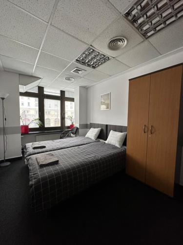 华沙Aleja "Solidarności"的一间卧室设有两张床和棕色橱柜