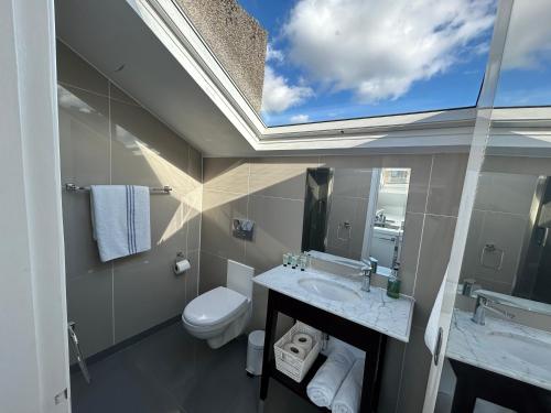 兰卡斯特Sun Street Aparthotel的一间带卫生间、水槽和窗户的浴室