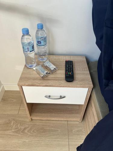 巴塞罗那Habitación confortable para parejas (1)的2瓶水和床头柜上的遥控器