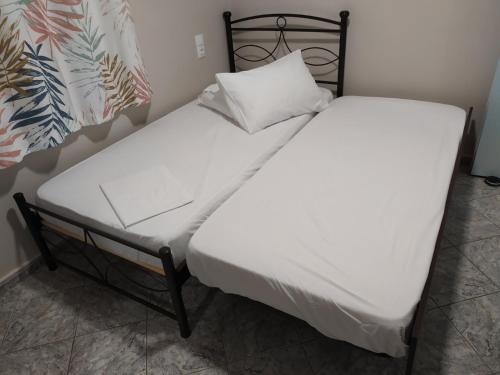 尼亚波利斯MEIMETIS GREEN HOUSE的一张带白色床单和枕头的床