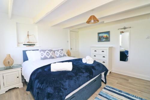 Saint ErvanCoastal retreat surrounded by open countryside的一间卧室配有一张带蓝色毯子的大床
