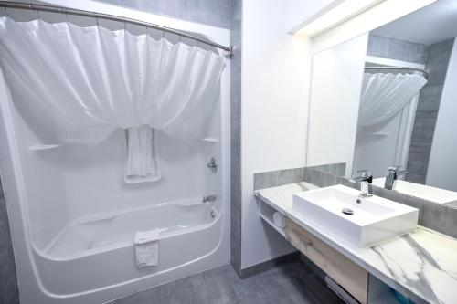AngersHôtel Napoléon的带淋浴和盥洗盆的白色浴室