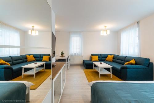 布拉索夫Red Fountain Studio的一间设有两张床和蓝色沙发的房间