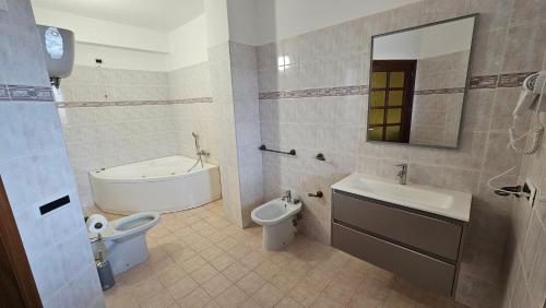 MiletoB&B Da Kociss的浴室配有盥洗盆、卫生间和浴缸。