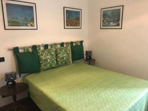 科哥莱托Chez Christine la petite的一间卧室配有一张带两张桌子的绿色床