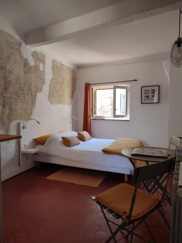 旺斯Chambre d'hôtes Les Tomettes的一间卧室设有一张大床和一个窗户。