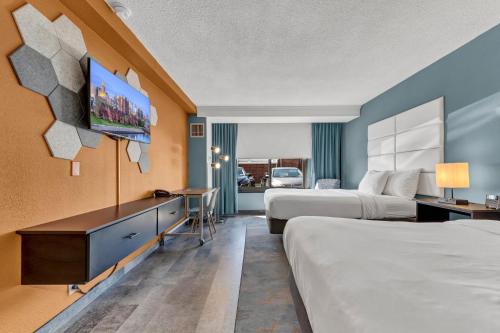 奇克托瓦加Buffalo Airport Hotel的酒店客房设有两张床和一台平面电视。