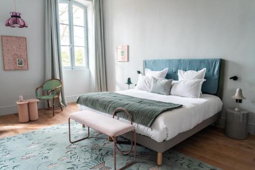 圣雷米普罗旺斯Domaine de Chalamon的一间卧室配有一张大床和一张粉红色凳子