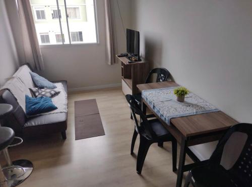 蓬塔格罗萨Apartamento novo wi-fi + TV的客厅设有餐桌和沙发