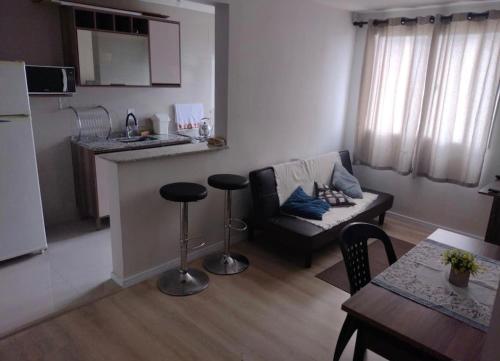 蓬塔格罗萨Apartamento novo wi-fi + TV的带沙发的小客厅和厨房