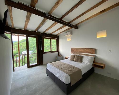 圣玛尔塔Akela Gaira Hotel的一间卧室设有一张床和一个大窗户