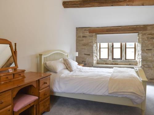 IngrowHigher Kirkstall Wood Farm的一间卧室配有一张床、一个梳妆台和一扇窗户。
