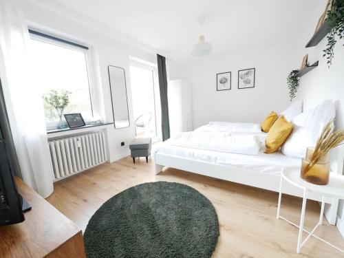 奥斯纳布吕克69 m², zentral, Balkon, stilvoll的白色卧室配有白色的床和绿色地毯