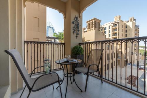 迪拜Ultimate Stay / Burj Al Arab View / Brand New / Amazing Pool with a View / Perfect Holiday / Madinat Jumeirah / 2 BDR的阳台配有桌椅,享有城市美景。
