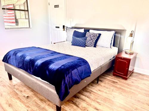 佩森Upgraded, Stylish & Comfy 1 Bedroom/1 Bath Studio的一张铺有蓝色和白色床单的床和床头柜