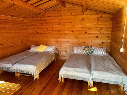 派尔努Karjamaa Garden Bungalows的小木屋设有两张木墙床
